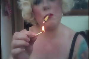 A Blonde Retro Mistress Smoking A On edge Sobranie Cigarette With Match Lambency