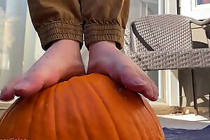 Urchin bare feet smashes pumpkin increased by plays with it